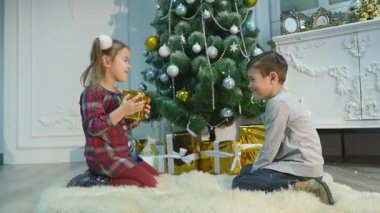 küçük kız ve erkek kardeşim hediye açmak. Noel ve yeni yıl kavramı