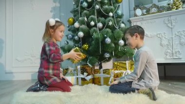 küçük kız ve erkek kardeşim hediye açmak. Noel ve yeni yıl kavramı