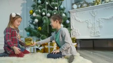 küçük kız ve erkek kardeşim hediye açmak. Noel ve yeni yıl kavramı
