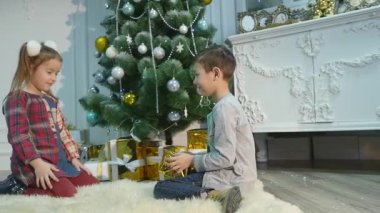küçük kız ve erkek kardeşim hediye açmak. Noel ve yeni yıl kavramı