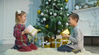 küçük kız ve erkek kardeşim hediye açmak. Noel ve yeni yıl kavramı