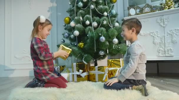 Дети распаковывают сюрприз на Рождество. Концепция праздников — стоковое видео