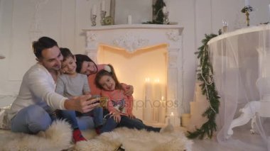 Mutlu aile portresi smartphone ile Noel sırasında evde alarak
