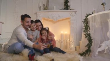 Mutlu aile portresi smartphone ile Noel sırasında evde alarak