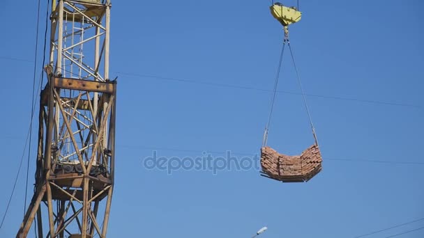 Grúa trabajando en la construcción en el cielo azul — Vídeo de stock