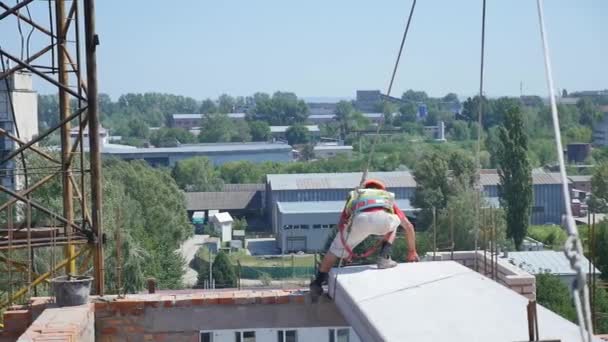 Bouwer werknemer in veiligheid beschermende uitrusting installeren betonnen vloer plaat panel op de werf van de bouw — Stockvideo