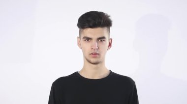 Güven eksikliği. Utangaç genç yakışıklı adam garip izole üzerinde gri duvar arka plan geliyor. İnsani duygular beden dili yaşam algı