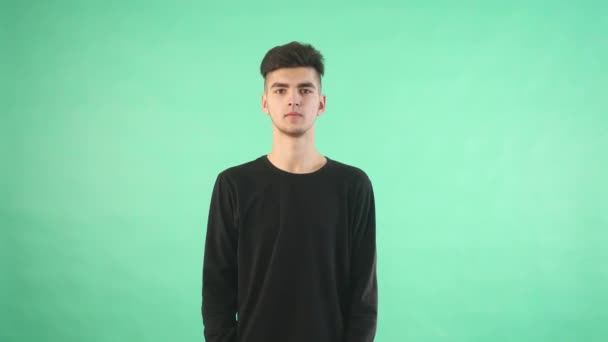 Молодий чоловік використовує віртуальні окуляри на зеленому тлі — стокове відео