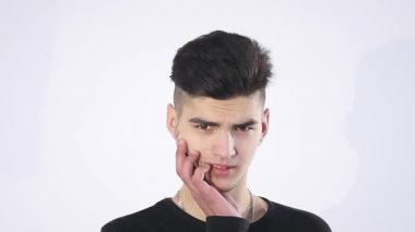 Güven eksikliği. Utangaç genç yakışıklı adam garip izole üzerinde gri duvar arka plan geliyor. İnsani duygular beden dili yaşam algı