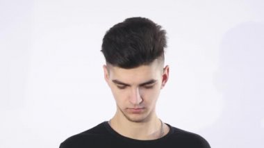 Gülümseyen genç adam akıllı telefonuna bakarken mesaj beyaz arka planda izole edilmiş.