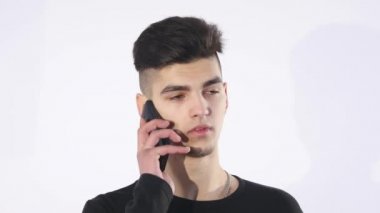 Gülümseyen genç adam akıllı telefonuna bakarken mesaj beyaz arka planda izole edilmiş.