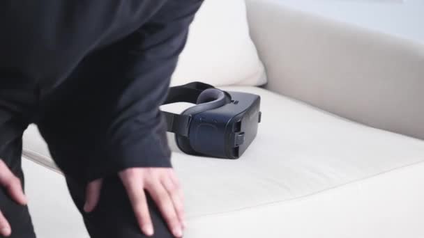 Tineri caucazian om stă pe canapea și se distrează folosind ochelari de căști alb VR — Videoclip de stoc