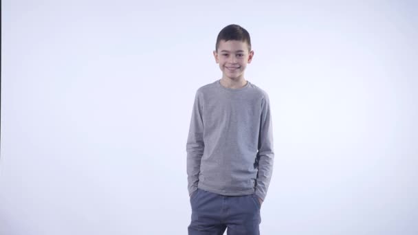 Милый улыбающийся счастливый мальчик изолирован на белом фоне — стоковое видео