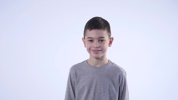 Niedlich lächelnd glücklich kleiner Junge isoliert auf weißem Hintergrund — Stockvideo