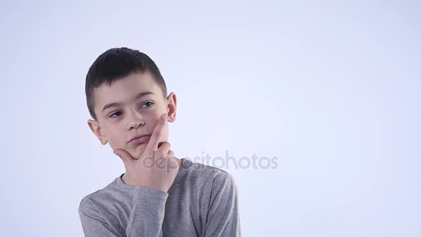 Niño pensando sobre fondo blanco — Vídeo de stock