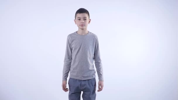 Portrait of confused clueless boy against white background. — Stock Video