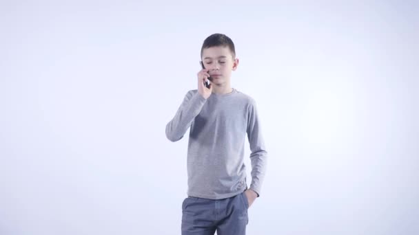 Kleine jongen met een telefoontje geïsoleerd op witte achtergrond — Stockvideo