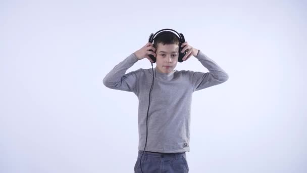 Niño adolescente feliz con auriculares, aislado sobre fondo blanco — Vídeos de Stock