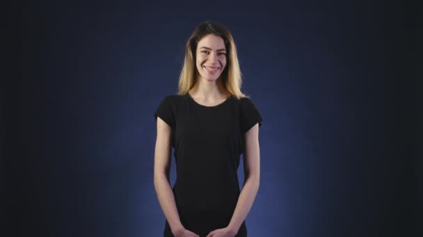 Schöne junge Frau auf dunklem Hintergrund — Stockvideo