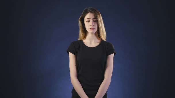 Chica triste sobre un fondo oscuro — Vídeo de stock