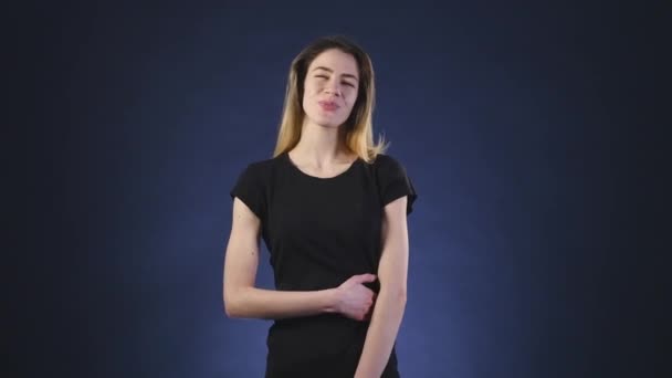 Satisfacción en la cara de la chica sobre un fondo oscuro — Vídeo de stock