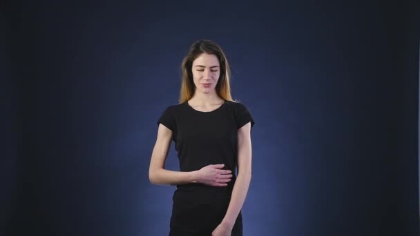 Tevredenheid op het gezicht van het meisje op een donkere achtergrond — Stockvideo