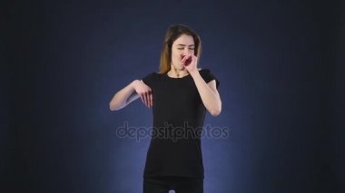 uzun saçlı genç kadın yorgun ve yawns, karanlık bir arka plan üzerinde izole