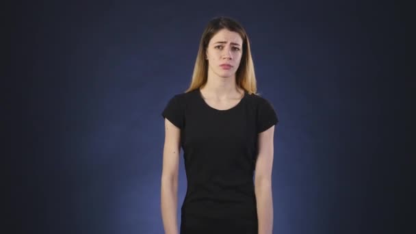 Disappointed girl on a dark background — Stock Video