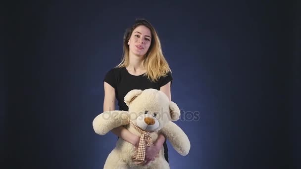 Meisje speelt met teddy bear - geïsoleerd op zwarte slowmotion — Stockvideo