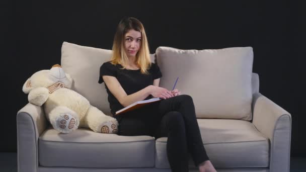 Kluge junge Frau macht sich mit Freude Notizen — Stockvideo