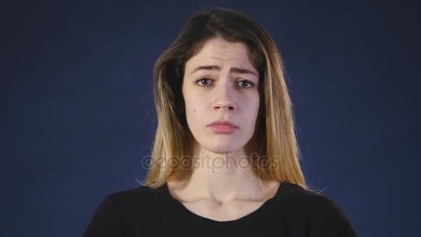 Chica triste sobre un fondo oscuro — Vídeo de stock