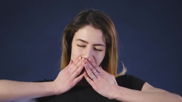 Длинноволосая молодая женщина устала и зевает, изолированная на темном фоне — стоковое видео