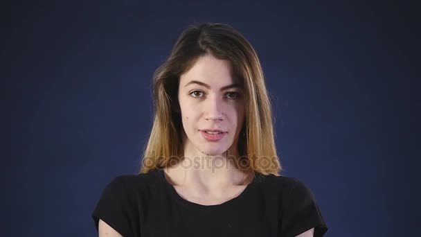 O femeie drăguță tânără albă se uită în camera de pe un fundal negru — Videoclip de stoc