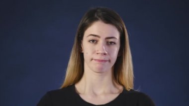 Sevimli genç bir beyaz kadın kameraya bir siyah arka plan üzerinde görünüyor.
