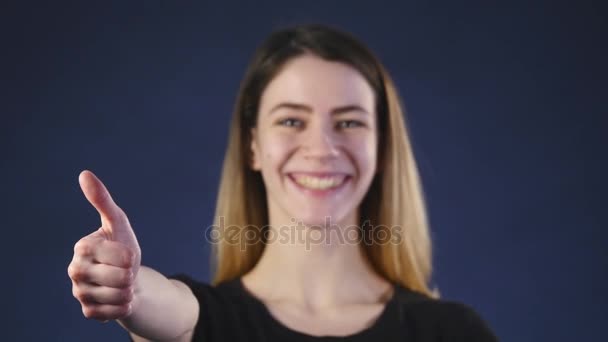 Uma bela jovem mulher sorrindo e mostrando os polegares para cima — Vídeo de Stock