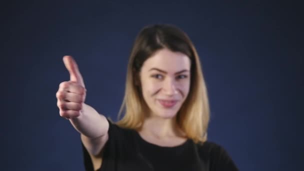 Uma bela jovem mulher sorrindo e mostrando os polegares para cima — Vídeo de Stock