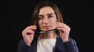 Camları koyu renk arka plan giyen güzel gülümseyen kadın