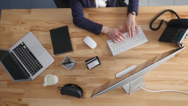 Hög vinkel syn på en ung brunett arbetar på hennes skrivbord med dokument och laptop. affärskvinna som arbetar på pappersarbete — Stockvideo