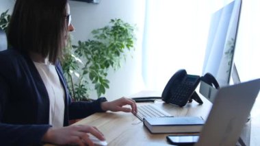 Onun işyerinde ofiste oturan bir işkadını arka görünümü portresi