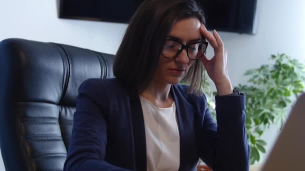 Gestresste Geschäftsfrau bei der Arbeit am Schreibtisch — Stockvideo