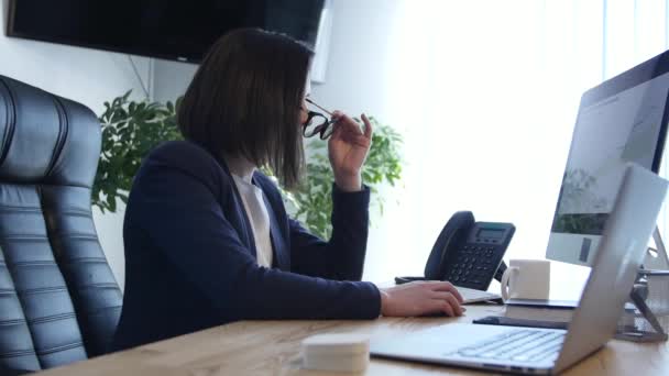 Donna d'affari stressata che lavora alla sua scrivania nel lavoro — Video Stock