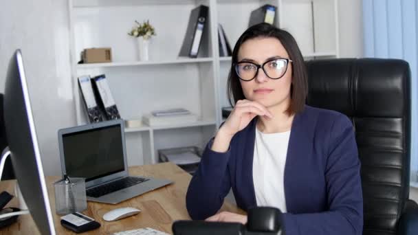 Erfolgreiche Geschäftsfrau im Büro blickt in die Kamera und lächelt — Stockvideo