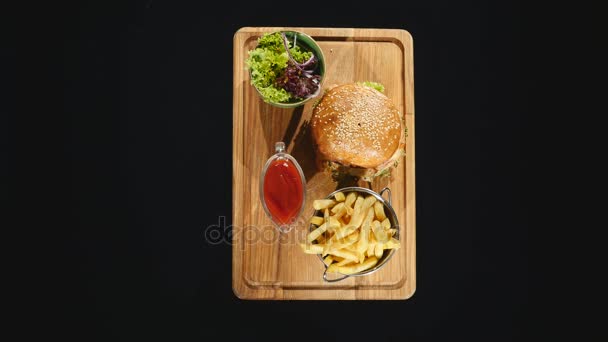 Hambúrgueres com batatas fritas na mesa. Vista superior de fast food. Pratos novos do menu. Comprar mais e obter descontos — Vídeo de Stock