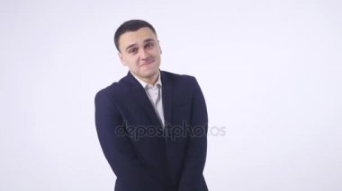 Gülümseyerek, kamera beyaz arka plan üzerinde seyir utangaç yakışıklı delikanlı