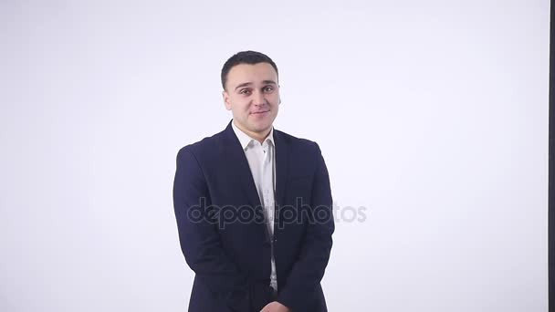 Shy young handsome man smiling, looking at camera over white background — Stock Video