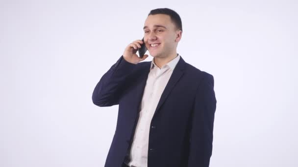 Portret van gelukkig jonge man praten op mobiele telefoon geïsoleerd op witte achtergrond — Stockvideo