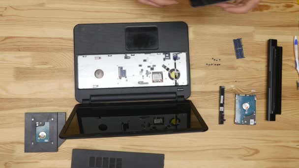 Mannelijke ingenieur reparaties laptop. Houten tafelblad weergave — Stockvideo