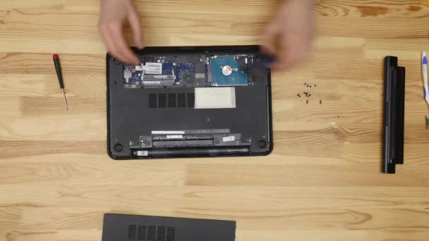 Ingegnere maschio ripara laptop. Tavolo in legno vista dall'alto — Video Stock