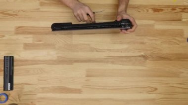 Erkek mühendis dizüstü onarır. Ahşap masa üstü görünümü