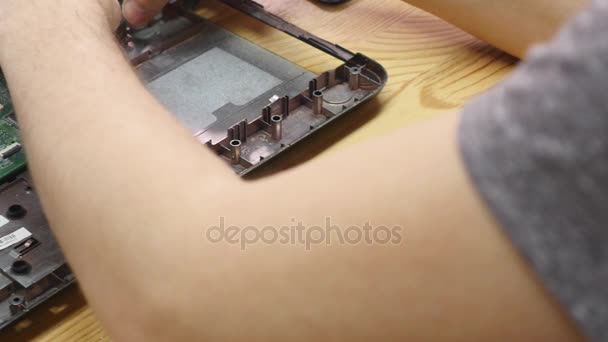 Desmontaje del portátil en taller de reparación, primer plano. Placa madre de computadora desmontada en el lugar de trabajo del reparador. Desarrollo electrónico, concepto de fijación de tecnología — Vídeo de stock